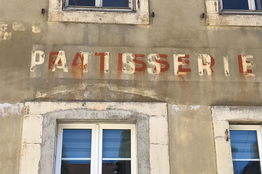 verblassende Typogafie an Hausfassade in Avenches